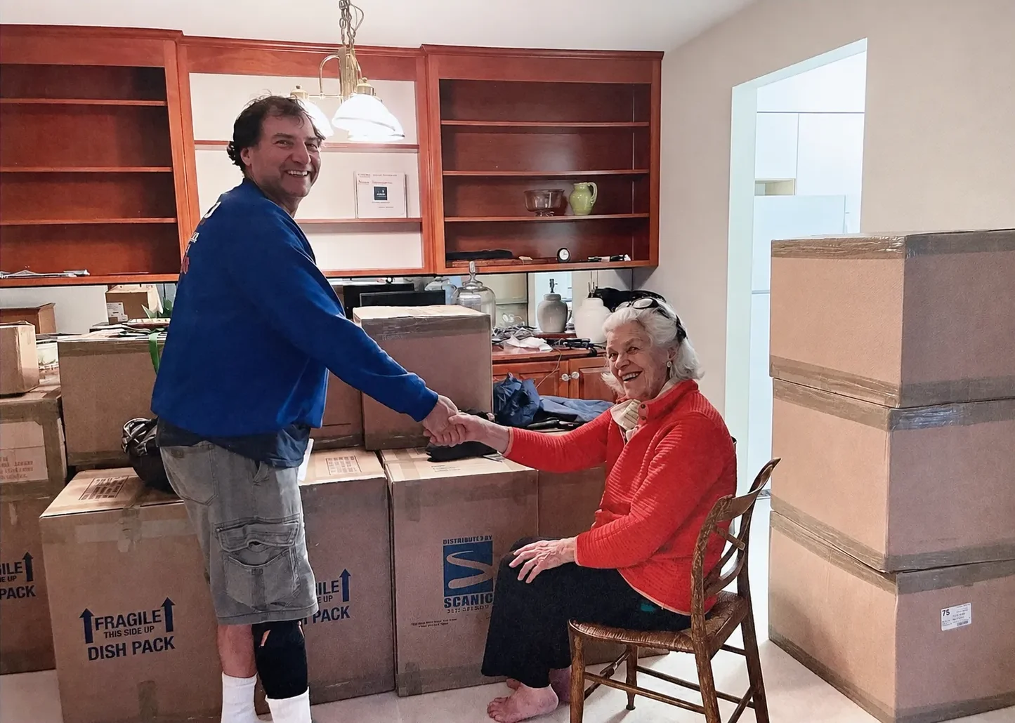 A Scanio mover shaking hands with a longtime client after a careful packing job